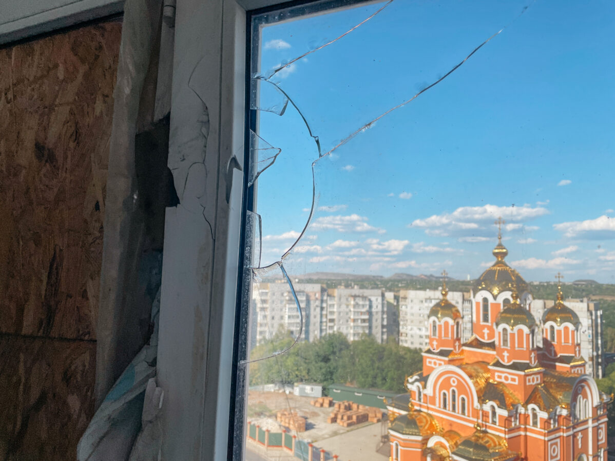 Вид на храм святого великомученика Пантелеимона Целителя из разбитого окна многоквартирного дома в Донецке