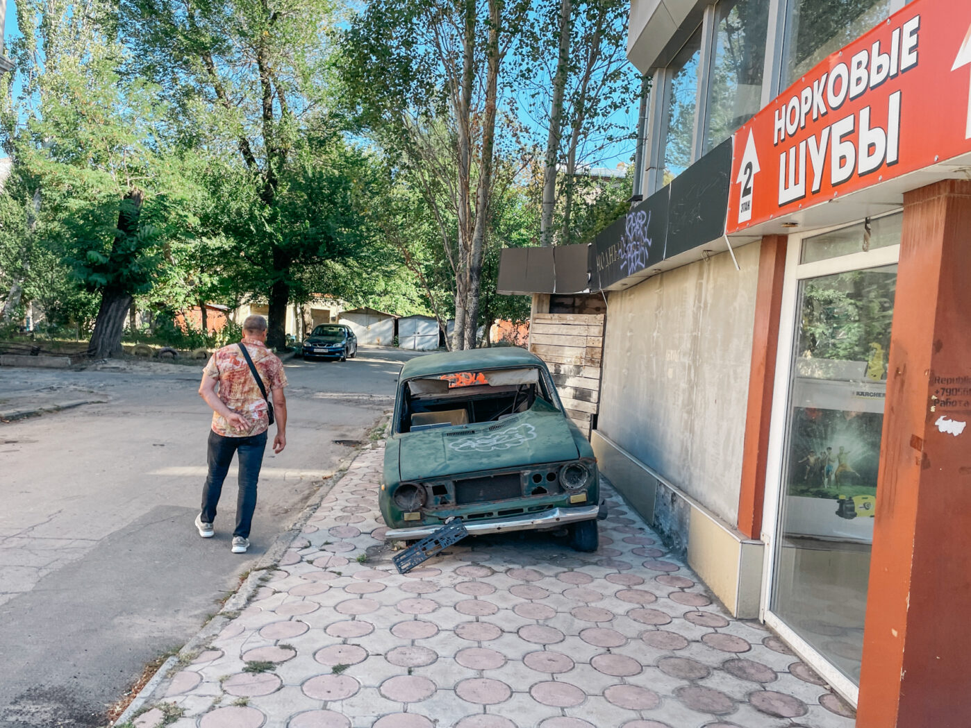 Разбитая машина на улице в Донецке — в городе отчётливо заметны следы войны